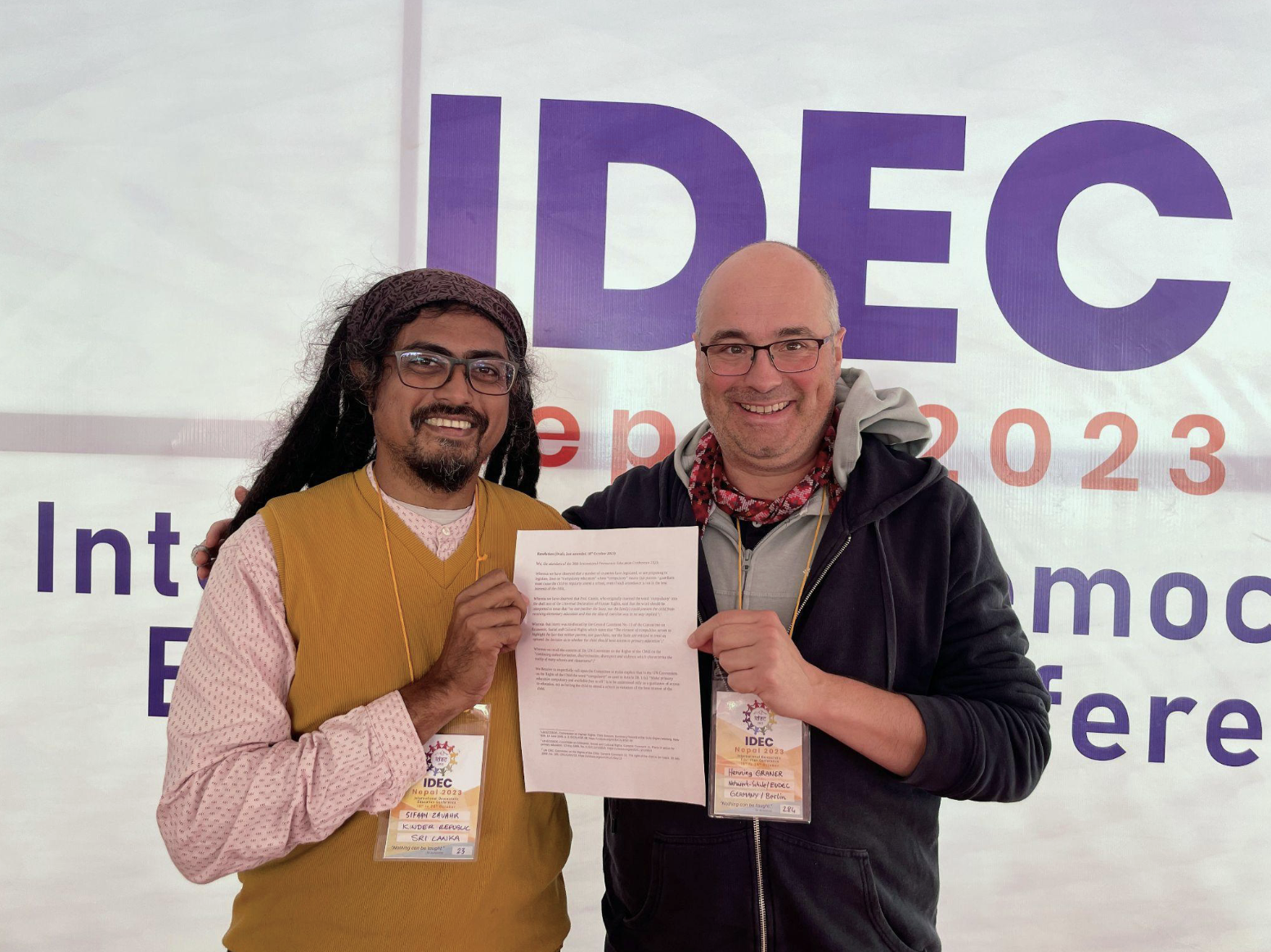 Sifaan Zavahir (left) of Sri Lanka and Henning Graner (right) of Germany celebrating the adoption of the resolution by the International Democratic Education Conference (IDEC) in October 2023 in Nepal